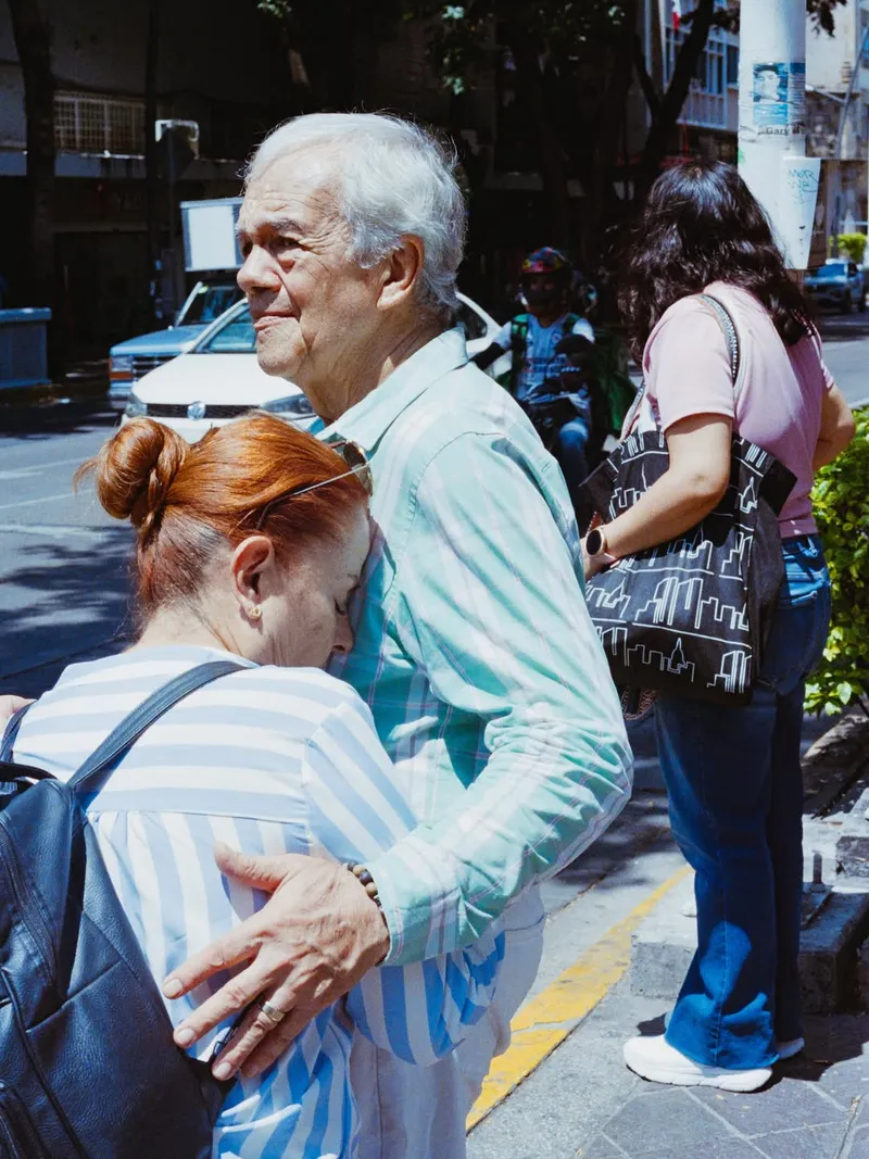 Pareja de adultos mayores abrazándose en la calle